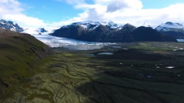 Yaz zamanı İzlanda 'nın güzel doğası ve güneşli havası. Yeşil dağları, tarlaları ve şelaleleri olan sihirli İzlanda.