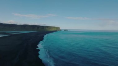 Reynisfjara Vik 'te büyük dalgaları olan İzlanda siyah kumsalı. Hava sineması 4K videosu. Güzel İzlanda doğa kıyısı yukarıdan.