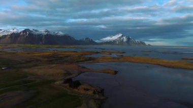 Dağların üzerinde renkli bir günbatımı. Ufukta Vestrahorn dağları olan İzlanda 'nın muhteşem hava manzarası.
