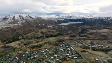 İzlanda 'nın kuzey kıyısında mavi gökyüzü ve bulutlarla dolu güzel bir günde tarihi Husavik kasabasının hava manzarası.