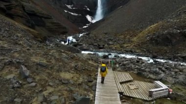 İzlanda 'yı keşfeden kız kırmızı çizgilerle Hengifoss şelalesine doğru yürüyor. Güzel İzlanda kaşifi.