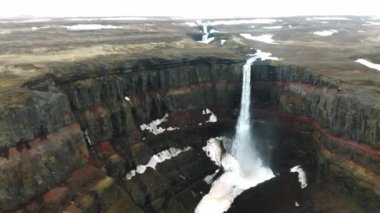 Hengifoss Şelalesi 'nin kırmızı şeritli havadan görünüşü ve İzlanda' da eski toprak volkanik oluşumu. Fırtınalı günlerde İzlanda 'nın güzel doğası.