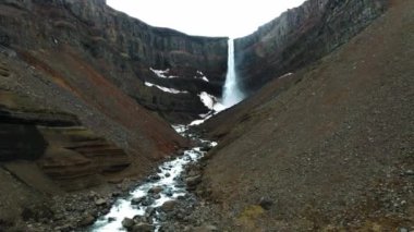 Hengifoss Şelalesi 'nin kırmızı şeritli havadan görünüşü ve İzlanda' da eski toprak volkanik oluşumu. Fırtınalı günlerde İzlanda 'nın güzel doğası.