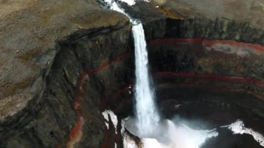 Hengifoss Şelalesi 'nin kırmızı şeritli havadan görünüşü ve İzlanda' da eski toprak volkanik oluşumu. Fırtınalı günlerde İzlanda 'nın güzel doğası.