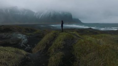 Stokksnes Burnu ve İzlanda 'daki Vestrahorn Dağı yakınlarında fırtınalı İzlanda' yı keşfeden genç bir kız..