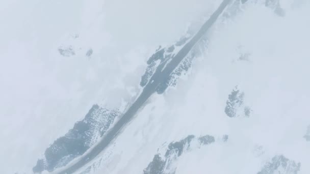 氷のアイスランド上空を雲の中を飛ぶ 冬は終わりだ 道路脇に車が停まっている美しいアイスランドの自然 — ストック動画