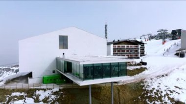 Karla kaplı dağda Alp restoranı ve müze. Alplerdeki beyaz manzarada dönüştürülmüş füniküler istasyonun panoramik görüntüsü. Lumen Müzesi.