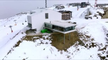 Karla kaplı dağda Alp restoranı ve müze. Alplerdeki beyaz manzarada dönüştürülmüş füniküler istasyonun panoramik görüntüsü. Lumen Müzesi.