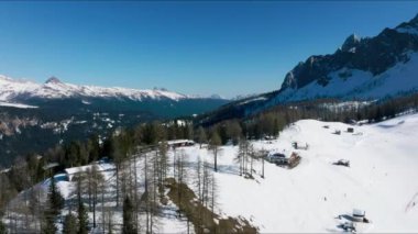 Kışın İsviçre 'nin ünlü Alp kayak merkezinin havadan görünüşü, karla kaplı binalar ve yamaçlar, açık mavi gökyüzü - yukarıdan Alp dağlarının manzarası, Avrupa.