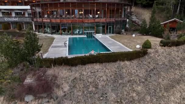 豪华酒店的空中景观 外面有一个无边的游泳池 旁边有一个年轻人在休息 — 图库视频影像