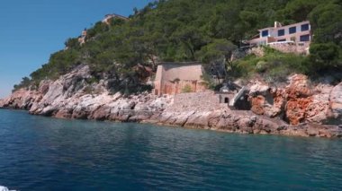 Denizdeki sürat teknesi tarafından yaratılan sörf. Mavi gökyüzüne karşı adanın güzel uçurum manzarası. Güneşli bir günde Akdeniz 'de su hareket ediyor. Güzel Palma De Mallorca adası.