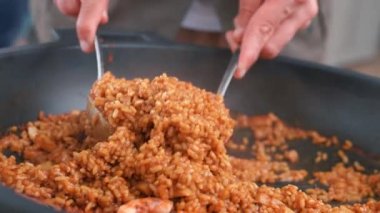 Çatal ve kaşıkla yemek pişiren bir adamın göbeği. Restoranda tabakta sağlıklı risotto. Erkeğin oteldeki yemeğinin keyfini çıkardığı yakın plan..
