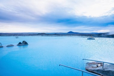 Jeotermal kaplıcadaki mavi göl manzarası. Bulutlu gökyüzüne karşı güzel, doğal bir kaplıca. Kış boyunca turistik turistik hareketin sakin manzarası.
