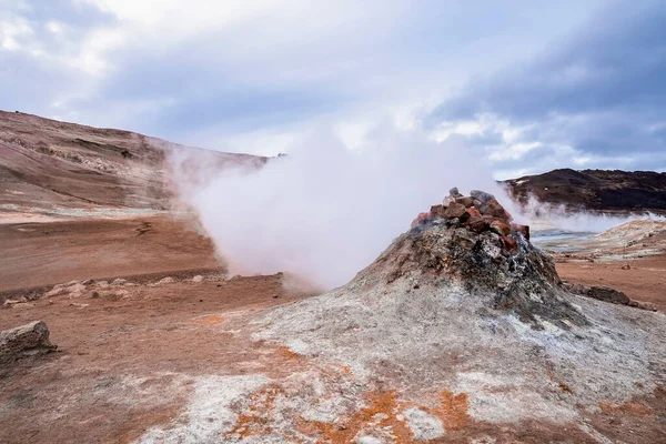 Steam emitting from fumarole in geothermal area at Namafjall. View of geyser in famous tourist attraction against sky. Sulphur dioxide erupting from volcanic crater of Hverir.