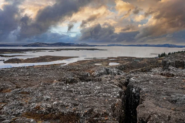 Göl kenarındaki güzel kaya oluşumlarının manzarası. Manzaralı manzara ve bulutlu gökyüzüne karşı dağlar. Kuzey Alp Bölgesi 'nde gün batımında resimli manzaranın ideal görünümü.