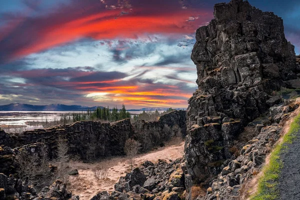 火山崖の上の岩の形成や木の風景 劇的な風景の中に美しい湖 日没時の曇天に対する絵のような牧歌的な風景 — ストック写真