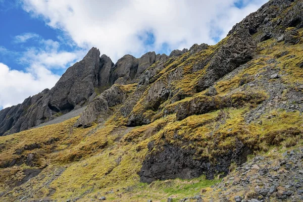 山の岩の形成の風景です 曇りの空に対して崖の上にパターン化された岩の低角度ビュー アルパイン地方の火山風景の美しい風景 — ストック写真