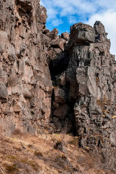 Kaya oluşumlarına karşı kurumuş ot. Bulutlu gökyüzüne karşı alçak açılı görkemli uçurum manzarası. Güzel kırsal doğa kavramı Kuzey Alp bölgesindeki doğal çevre.