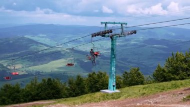 Sandalyeyle bisiklet süren bir turist yaz günü yeşil tepenin içinden geçiyor. Yeşil tepenin üzerinde bisikletli genç adam off-road bisikletine hazırlanıyor.. 