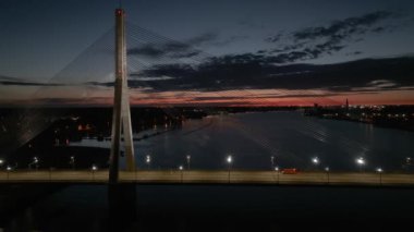 Geceleri Daugava nehri üzerindeki Riga köprüsünün hava panoramik görüntüsü. Geceleri Letonya, Riga 'da kablolu köprü.