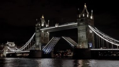 Panoramik gece manzaralı sembolik ünlü aydınlanmış Tower Bridge yolu kaldırıyor. Gece yükselen kule köprüsü.