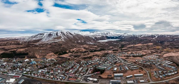 Aerial scenic view of the historic town of Husavik on a beautiful day with blue sky and clouds, north coast of Iceland