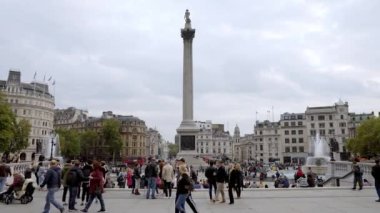 Londra 'daki Trafalgar Meydanı' nda yoğun bir öğleden sonra. Meydanı ve Ulusal Galeri 'yi ziyaret eden yerli ve turistler. 4k video.