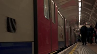 Londons metro istasyonundaki yolcularla birlikte tren peronunda. Londra metro 4k video.
