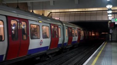 Londons metro istasyonundaki yolcularla birlikte tren peronunda. Londra metro 4k video.