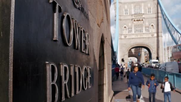 英国伦敦一座塔桥墙上的一个塔桥标志的场景视频 人们赶着过桥的车辆冲下了桥 — 图库视频影像