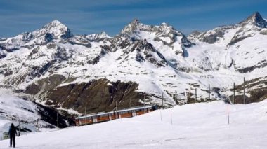 Zermatt 'taki Matterhorn Dağı' ndan geçen tren. Demiryolu aracı Gornergrat istasyonuna doğru koşuyor. Kış boyunca Alpler 'deki mavi gökyüzü karla kaplıydı..