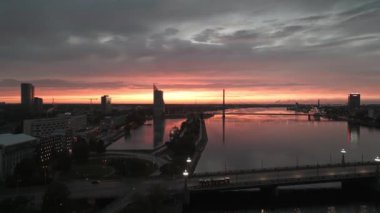 Geceleyin Riga şehrinin üzerinde büyülü bir günbatımı. Riga 'da kablo destekli köprü ya da gün batımında Vansu eğiliyor. Güzel Riga şehri gece manzarası.