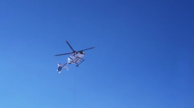 Kurtarma helikopteri yamaçlara iniyor kayakçıya kayak parkında yardım ediyor. Alplerdeki hava ambulansı. Kurtarma aracı.