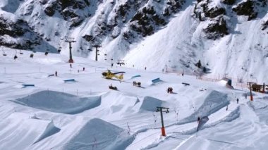 Kurtarma helikopteri yamaçlara iniyor kayakçıya kayak parkında yardım ediyor. Alplerdeki hava ambulansı. Kurtarma aracı.