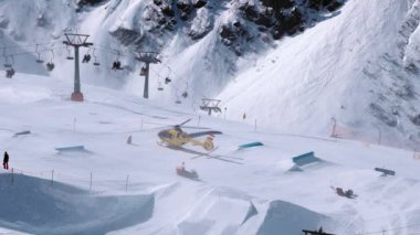 Kurtarma helikopteri yamaçlara iniyor kayakçıya kayak parkında yardım ediyor. Alplerdeki hava ambulansı. Kurtarma aracı.