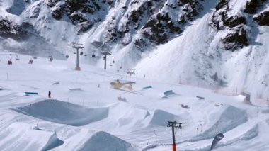 Kurtarma helikopteri yamaçlara iniyor kayakçıya kayak parkında yardım ediyor. Alplerdeki hava ambulansı. Kurtarma aracı.