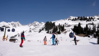 Kayakçı yamaçlarda karlı arazide kayak yapıyor. Turistler macera sporunu seviyor. Avusturya Alplerinde güneşli bir günde manzaralı dağ sıraları. 