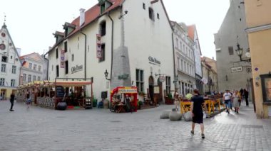 Sıcak bir yaz gününde Estonya 'nın eski Tallinn kasabasında dolaşan turistler.
