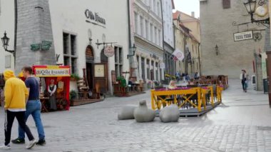 Sıcak bir yaz gününde Estonya 'nın eski Tallinn kasabasında dolaşan turistler.