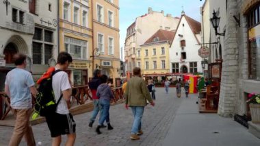 Sıcak bir yaz gününde Estonya 'nın eski Tallinn kasabasında dolaşan turistler.
