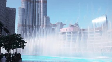 Dubai 'deki Burj Khalifa gökdeleninin yakınlarında dans eden çeşmeler. Güneşli bir günde 150 m yüksekliğe ulaşan dünyanın en büyük çeşmeleri. 