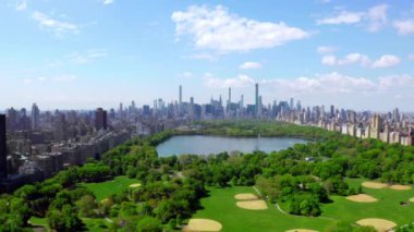 New York, Manhattan 'ın ortasındaki Green Central Park' ın üstünde geçen havadan 4K video. Güzel New York şehri yukarıdan.