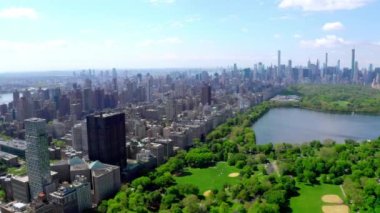New York, Manhattan 'ın ortasındaki Green Central Park' ın üstünde geçen havadan 4K video. Güzel New York şehri yukarıdan.