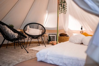 Boho tarzında güzel beyaz bir dekor. Doğada piknik, masa, halılar, çadır, parkta yastıklar. Doğa konseptinde tatiller.