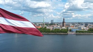 Slow motion of the Latvian flag with the Dome Cathedral and an old town in the background in Riga, Latvia, the Baltic countries