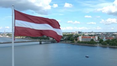 Kubbe Katedrali ile Letonya bayrağının yavaş hareketi ve Riga, Letonya, Baltık ülkeleri arka planında eski bir kasaba