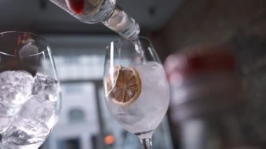 Aperol Spritz Kokteyli hazırlıyorum. Barmenlerin elleri bardağa buz ve portakal yağı serpiştirilmiş kokteyl döküyor. Uzun köpüklü içecek..