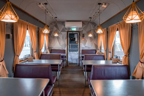 Aydınlatılmış tren vagonu restoranındaki masalar ve koltuklar. Peatus 'taki durağan demiryolu araç restoranının içinde. Tarihi Tallinn kasabasında ünlü turist eğlencesi