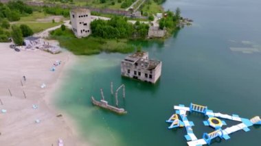 Abandoned quarry for extraction of limestone. Beautiful nature, attraction in Estonia. The summer season. Aerial Rummu quarry lake with underwater prison in the middle