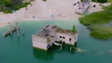 Abandoned quarry for extraction of limestone. Beautiful nature, attraction in Estonia. The summer season. Aerial Rummu quarry lake with underwater prison in the middle